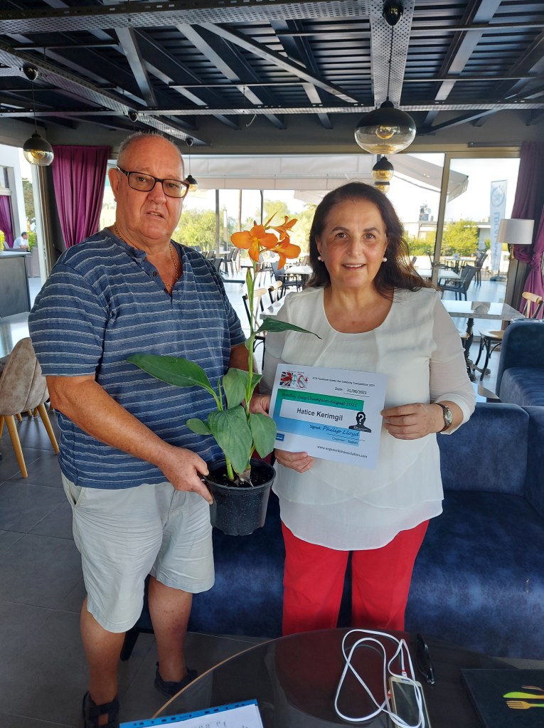 AUGUST 2021 Monthly prize winner (person with the most correct guesses during the month) is: - Hatice Kerimgil seen here receiving her prize and certificate from the association chairman