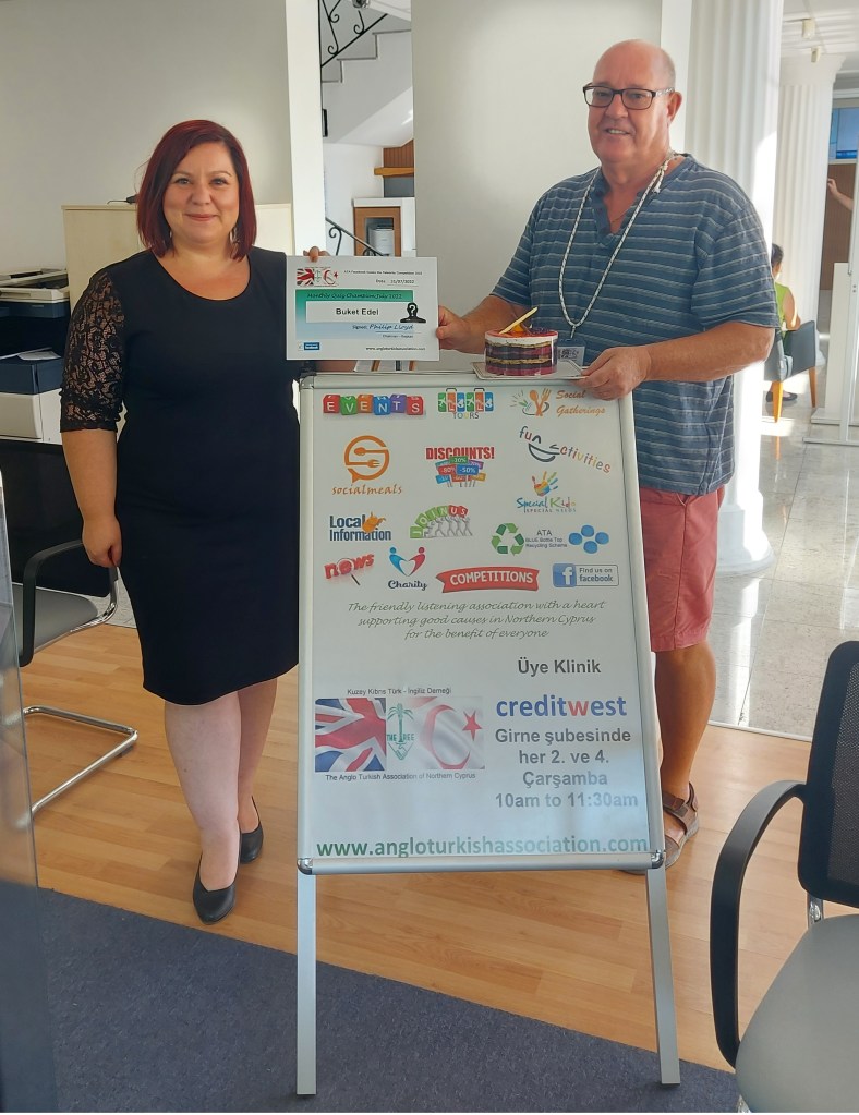 JULY 2022 Monthly prize winner (person with the most correct guesses during the month) is: - Buket Edel seen here receiving her prize and certificate from the association chairman