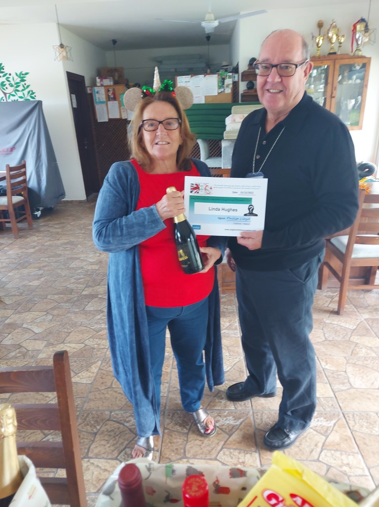 DECEMBER 2022 Monthly prize winner (person with the most correct guesses during the month) is: - Linda Hughes seen here receiving her prize and certificate from the association chairman