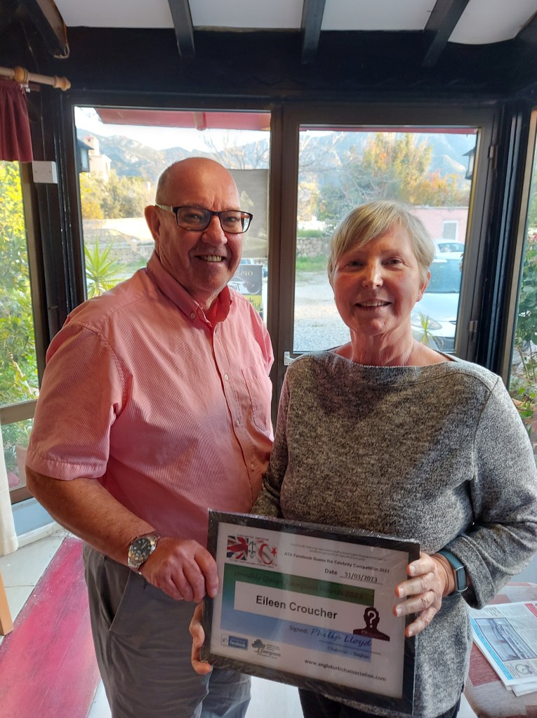 MARCH 2023 Monthly prize winner (person with the most correct guesses during the month) is: –  Eileen Croucher (R) seen here receiving her winners certificate from the association's Chairman