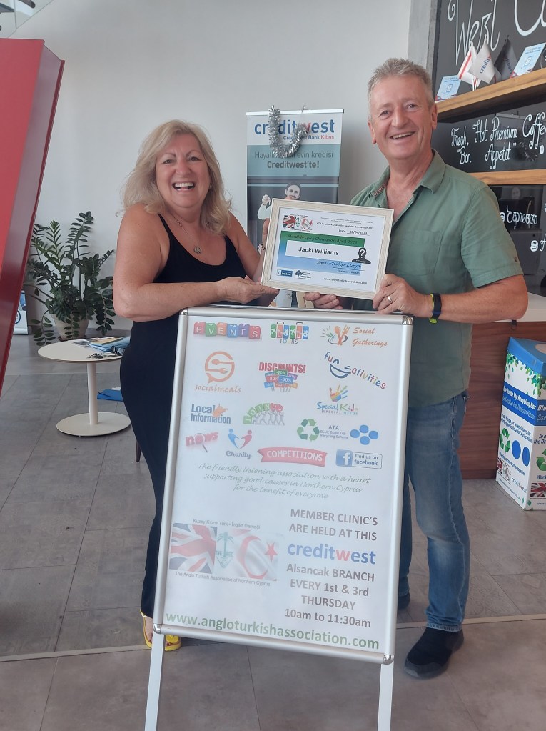 APRIL 2023 Monthly prize winner (person with the most correct guesses during the month) is: –  Jacki Williams (L) seen here receiving her winners certificate from the association treasurer Tim Morgan